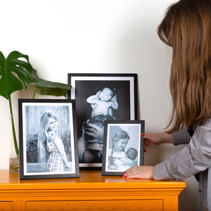 Black Picture Frame, A4 , A3 & A2 Black Frames being placed on a yellow dresser by a girl next to a Monestera cutting in vase